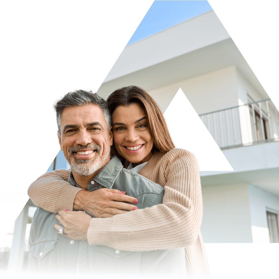 an elderly couple against the backdrop of a new house.